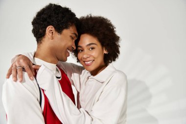 Tarz sahibi genç bir çift, estetik giysileriyle sevgi ve mutluluk saçarak kucaklaşır..