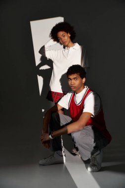 Genç bir çift cesur gölgelerin arasında birlikte poz veriyor, derin bağlantılarını ve tarzlarını ifade ediyorlar..