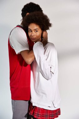 Bir çift şık bir ortamda duruyor, derin bağlantılarını nazik bir dokunuşla gösteriyorlar..