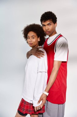 Genç bir çift birbirine yakın durur, romantizm ve stili somutlaştırırlar, minimalist bir arkaplanda..