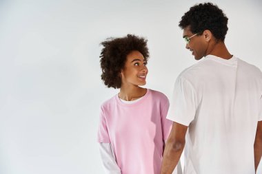 Genç çift neşeli bir bakışı paylaşıyor, sevgi ve bağın vücut bulmuş halidir..