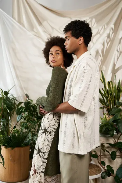 Bir çift, canlı bitkilerin arasında, samimi bir ortamda romantizm yayıyor..