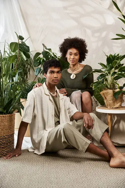 Neşeli bir çift birlikte poz veriyor. Etrafı yemyeşil bitkilerle çevrili. Aşklarını ve tarzlarını sergiliyorlar..