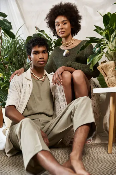 Birbirini seven çiftler, yemyeşil bitkilerin arasında birbirlerini kucaklıyor, moda tarzlarını ve bağlantılarını sergiliyorlar..