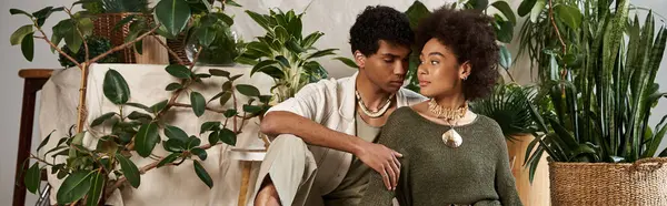 Genç bir çift yemyeşil bir ortamda birbirine yakın oturuyor, sevgi ve bağ yayıyorlar..