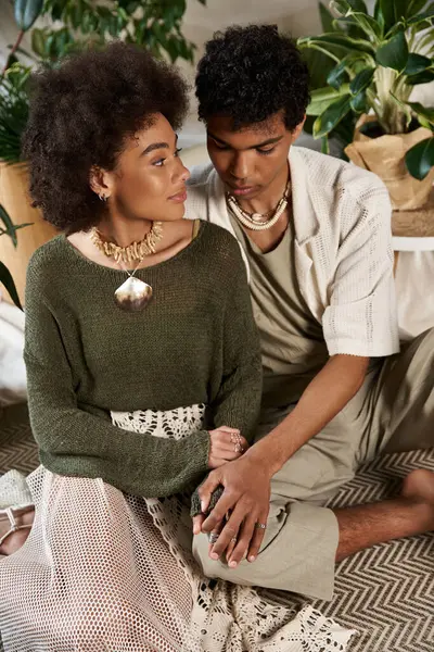 Genç bir çift sıcak bir uzayda, bitkilerin ve canlı dokuların arasında samimi bir anı paylaşıyor..