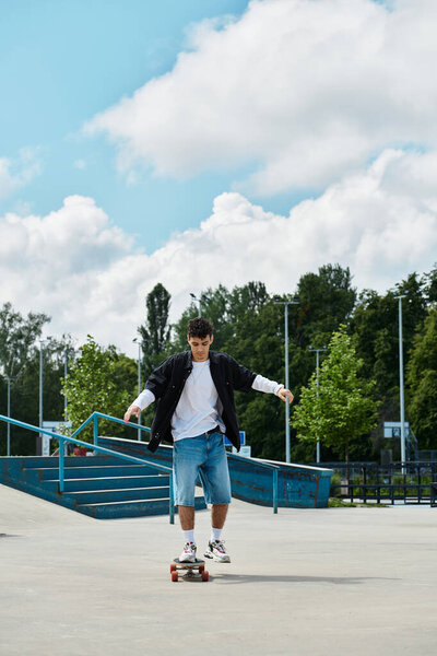 Молодой человек любит кататься на скейтборде в оживленном парке, окруженном зеленью в солнечный день.