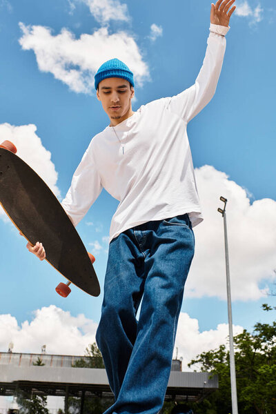 Молодой парень наслаждается временем в парке, демонстрируя свои навыки скейтборда на солнечном фоне.