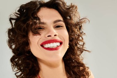 Parlak giyimli kadın coşkulu bir gülümsemeyle neşe saçıyor, yaz zarafetini somutlaştırıyor..