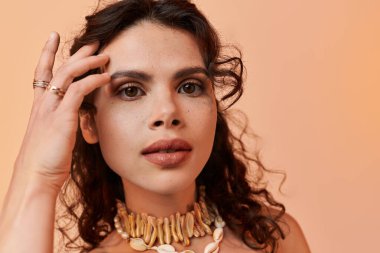 Şık yaz kıyafetleri ve aksesuarları içinde zarif poz veren çekici genç bir kadın..