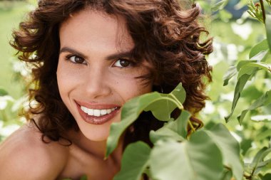 Genç kadınlar açık havada güneşli bir yaz gününde yemyeşil alanda ışıl ışıl gülümserler..