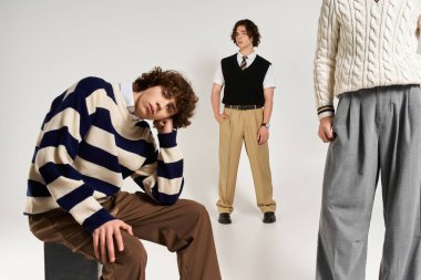 Modaya uygun genç erkekler modaya uygun kıyafetlerini gösterirken bir anlık dostluk paylaşıyorlar..