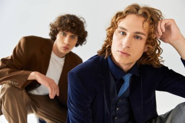 İki genç adam çağdaş moda eğilimleri sergiliyor, güven ve tarz yayıyorlar..