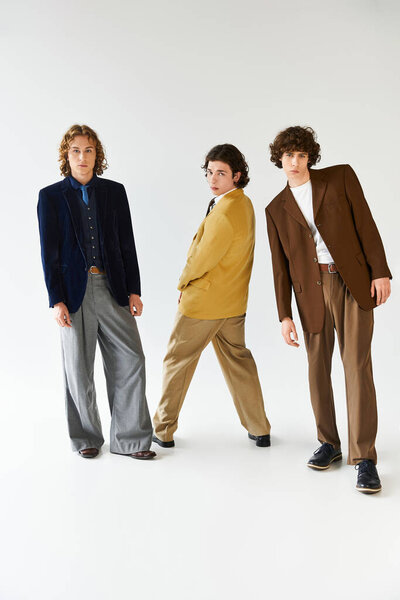 Three young men showcase unique styles and camaraderie in fashionable outfits.