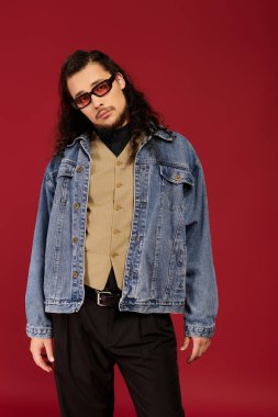 Yakışıklı genç adam şık poz veriyor, eski ve modern modayı çarpıcı renklerle harmanlıyor..