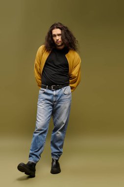 Sakallı şık bir genç adam rahatlamış, sıradan moda ve karizmasını sergiliyor..