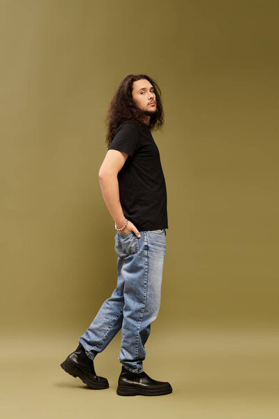 Young bearded man stands confidently, exuding charm and poise in a relaxed setting.