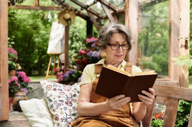 Yaşlı kadın bahçede canlı çiçeklerle çevrili huzurlu bir anın tadını çıkarıyor..