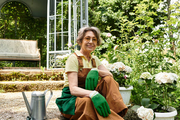 A smiling senior woman kneels in her garden, tending to flowers amid lush greenery.