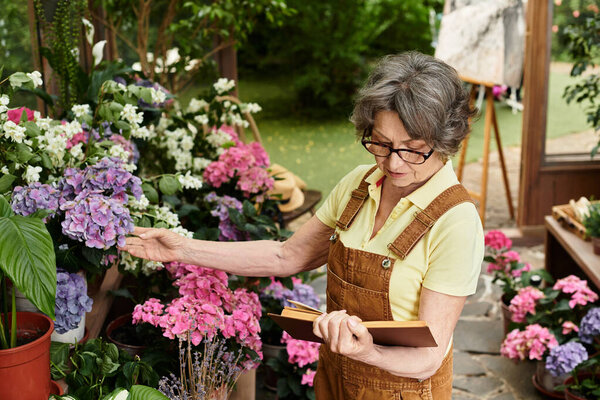 Senior woman enjoys her time in a colorful garden, surrounded by beautiful flowers and plants.