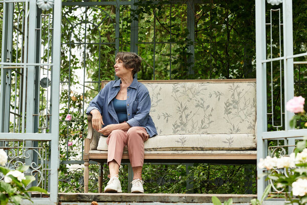 Senior woman relaxes on a garden bench, appreciating the beauty of her blooming oasis in spring.