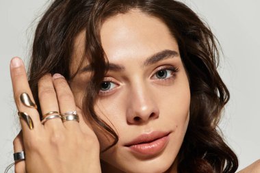 Çekici genç bir kadın stüdyoda zarif pozlar veriyor, büyüleyici özelliklerini vurguluyor..