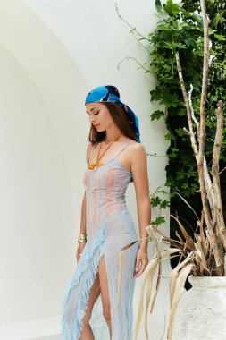 Parlak genç bir kadın yaz tarzını sergiliyor. Rüzgarlı bir ortamda, açık hava havasını kucaklıyor..