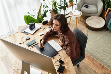 Serbest çalışan, grafiksel tablet üzerinde çalışmaya dalmış, sanatsal yeteneklerini rahat bir evde sergiliyor..