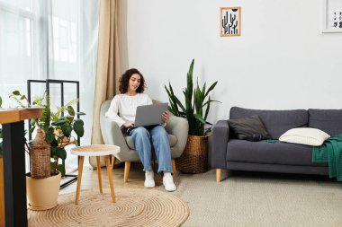 Kıvırcık saçlı serbest çalışan, şık ev ofisinde rahatça otururken uzaktan kumandalı işlere girişiyor..