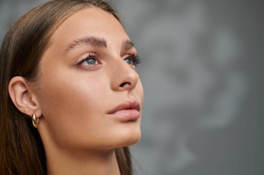 Bronz tenli ve doğal makyajlı güzel bir kadın stüdyoda zarif pozlar veriyor..