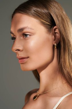 Genç bir kadın bronz tenini ve doğal makyajını bir yaz stüdyo çekiminde sergiliyor..