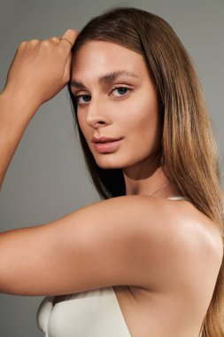 Parlak yaz titreşimleri, doğal makyajını ve bronzlaşmasını gösteren genç bayandan yayılıyor..