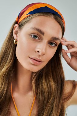 Bronz tenli şık bir genç kadın başörtüsü takar, doğal güzelliği olan yaz atmosferini ifade eder..