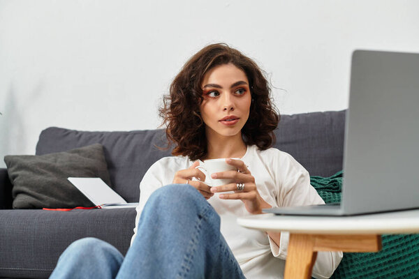 Фрилансер потягивает кофе, фокусируясь на ноутбуке в комфортном жилом помещении.
