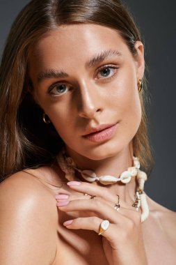 Işıldayan doğal güzellik, genç bir kadın deniz kabuğu kolyesiyle yaz görüntüsünü sergiliyor..