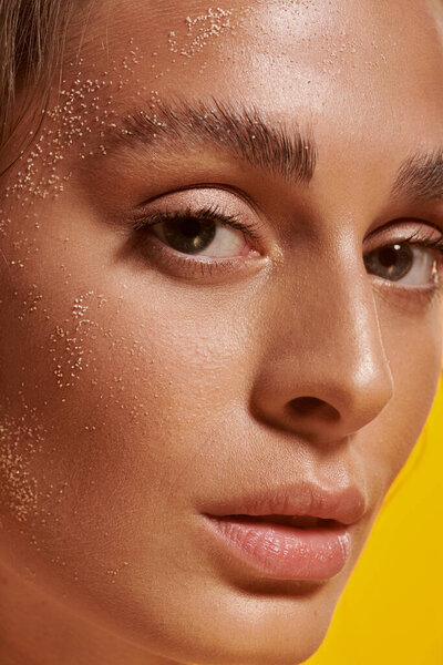 A beautiful young woman showcases summer beauty in a bright studio.