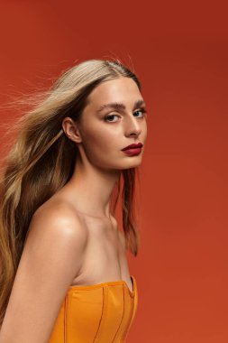 Göz kamaştırıcı genç bir kadın uzun saçlarıyla zarif bir şekilde poz veriyor..