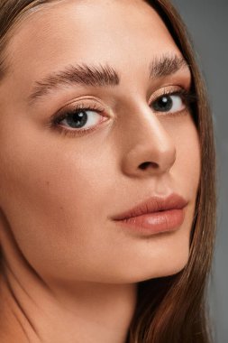 Genç ve güzel bir kadın kameraya özgüvenle bakıyor, doğal güzelliğini ve çekiciliğini sergiliyor..