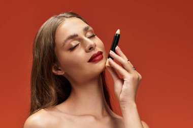 Genç bir kadın zarafetini ön plana çıkarırken cesur bir arka plana makyaj yapıyor..