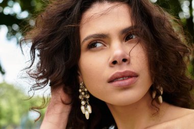 Genç bir kadın yemyeşil bir parkta geziniyor, doğanın tadını çıkarıyor..