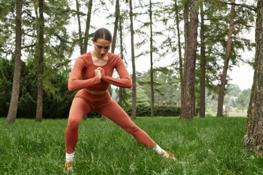 Yoga öğretmeni, sakin bir açık hava ortamında esnerken güç ve odaklanma gösteriyor..