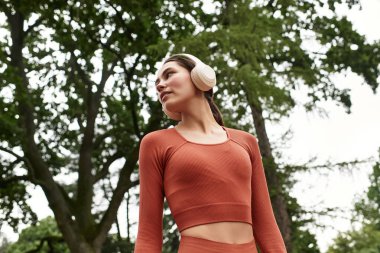 Genç bir yoga hocasının yemyeşil ağaçların altında huzuru kucakladığı huzurlu anlar..