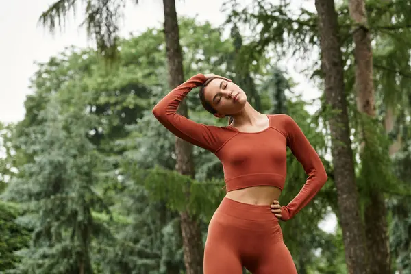 Güzel bir kadın, huzurlu bir ortamda yemyeşil bir ortam içindeyken yoga pozları veriyor..