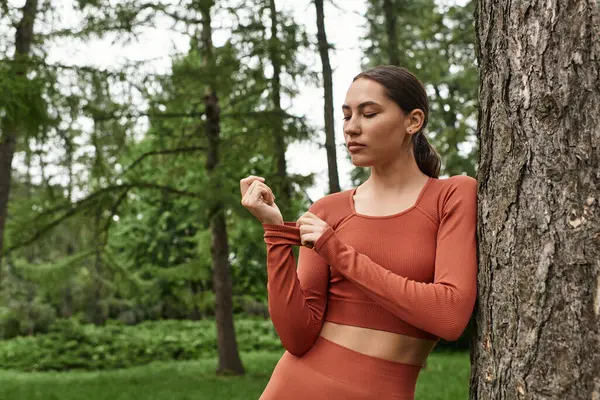 Genç bir kadın yoga yaparken doğanın sakinliğinin tadını çıkararak nefesine odaklanıyor..