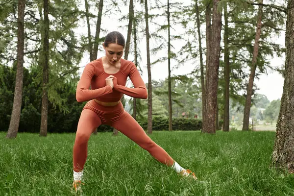 Yoga öğretmeni, sakin bir açık hava ortamında esnerken güç ve odaklanma gösteriyor..