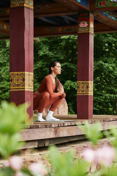 A young beautiful woman practices yoga outdoors, harmonizing with natures tranquility.