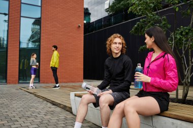 Genç arkadaşlar sıcak bir günde sportif tarzlarını sergileyerek canlı sohbetler yaparlar..