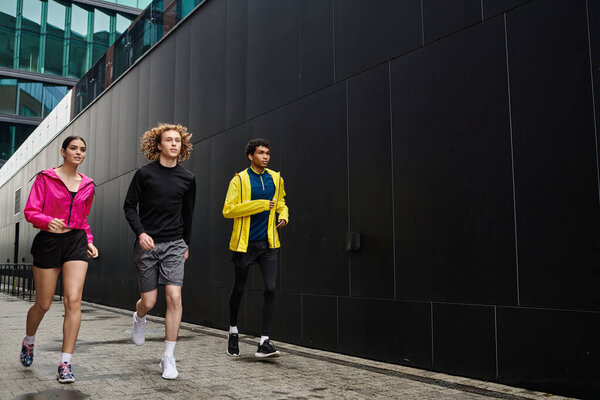 Three athletes jog together on a modern urban path, highlighting teamwork and fitness.