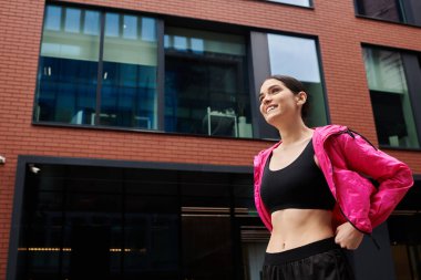 Atletik şahıs, kentteki açık hava eğitimini tamamladıktan sonra kendinden emin bir şekilde gülümsüyor..