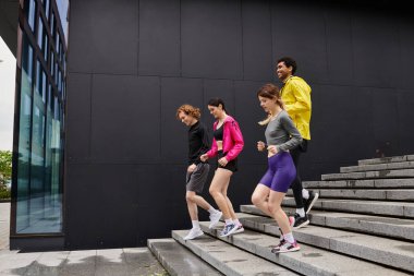 Dört enerjik birey şehir basamaklarında atletik bir aktivite içinde, takım çalışması sergiliyorlar..